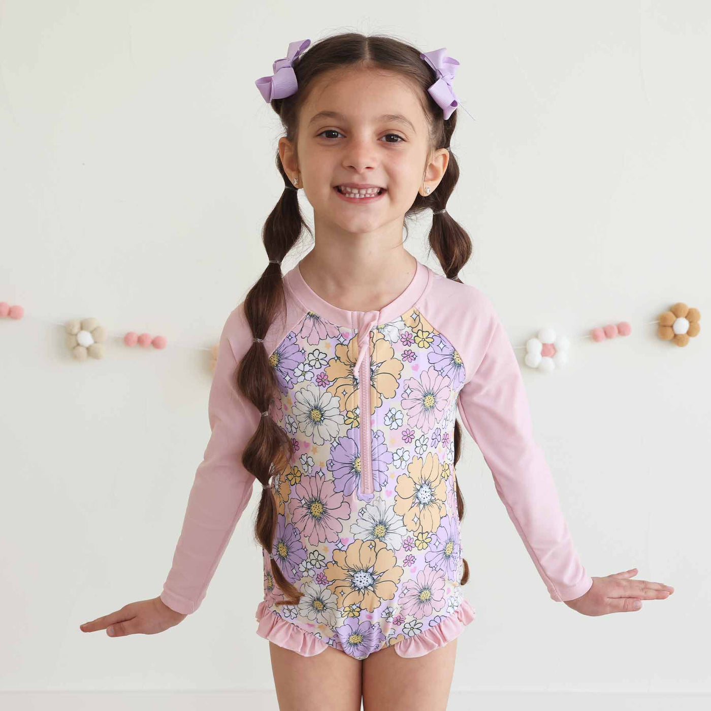 zip romper for girls with pastel daisies 