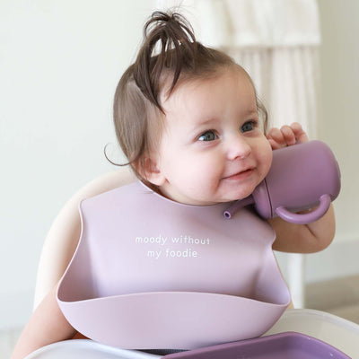 purple baby bib made of silicone with saying 