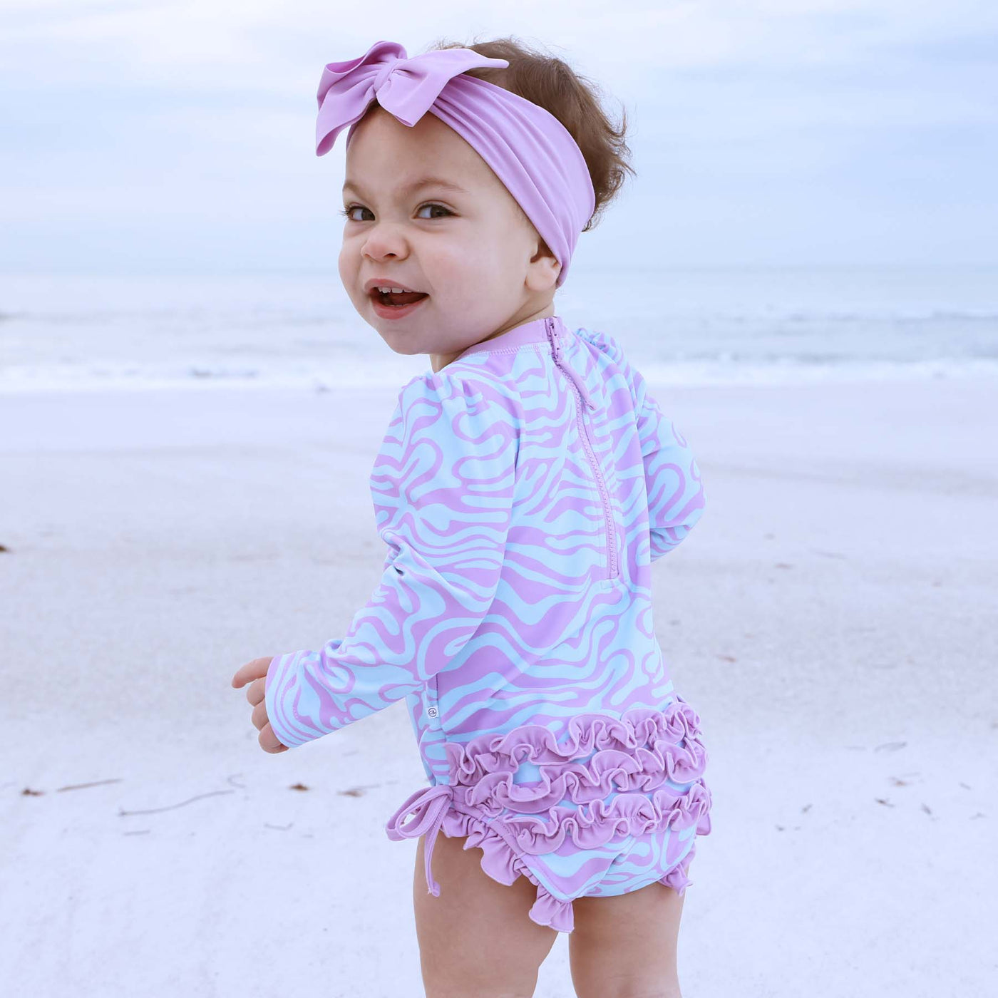ruffle butt rash guard swimsuit for babies with blue and purple squiggly lines 