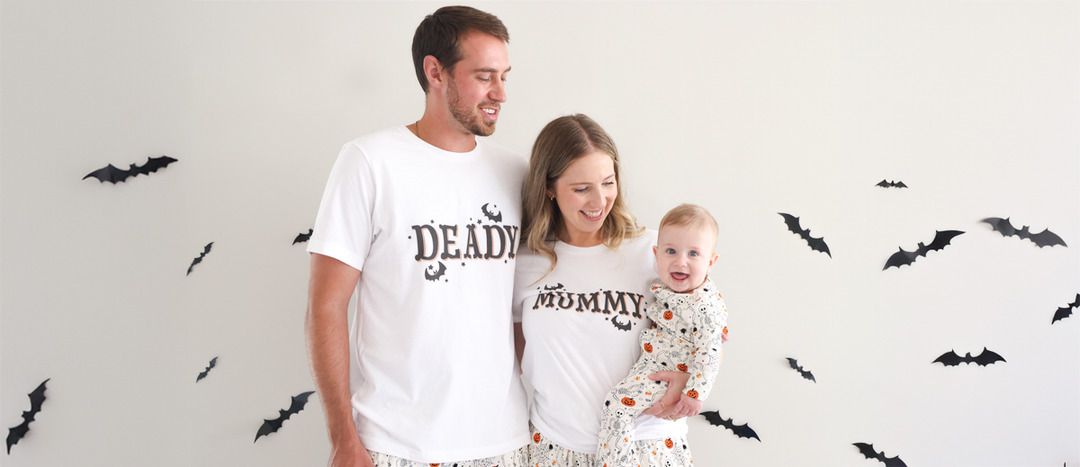 Mom, dad and baby in Caden Lane's family-matching Halloween pajamas