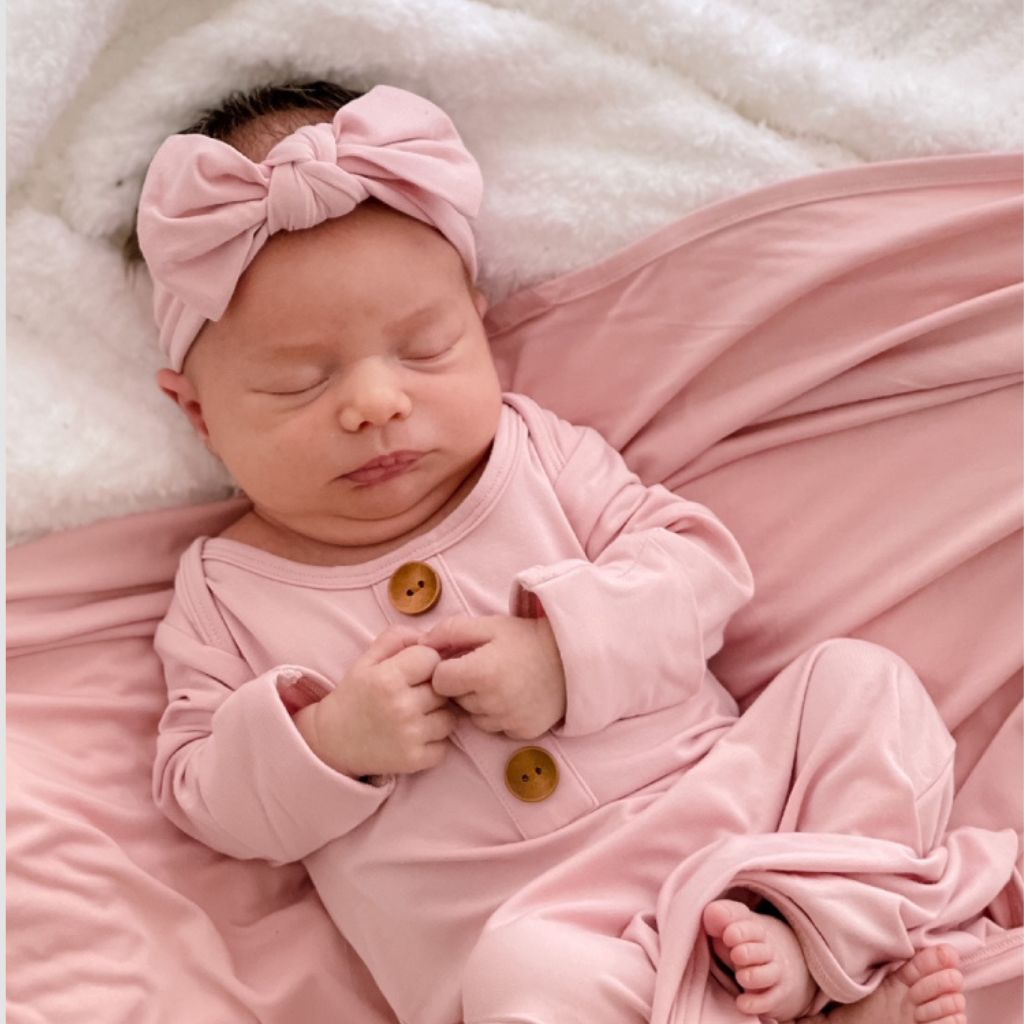 baby wearing solid mauve knotgown and matching bow. 