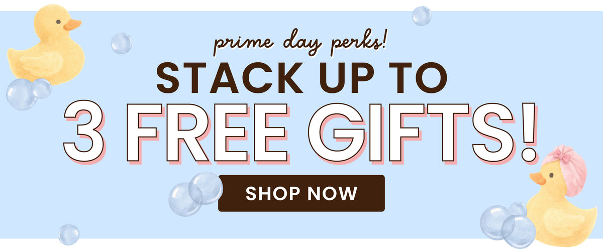 A Caden Lane Prime days promotional banner with the text 'prime day deals! STACK UP TO 3 FREE GIFTS!' in large outlined letters, a dark brown 'SHOP NOW' button, and two small yellow rubber duckies on a pale blue background with faint bubble shapes.