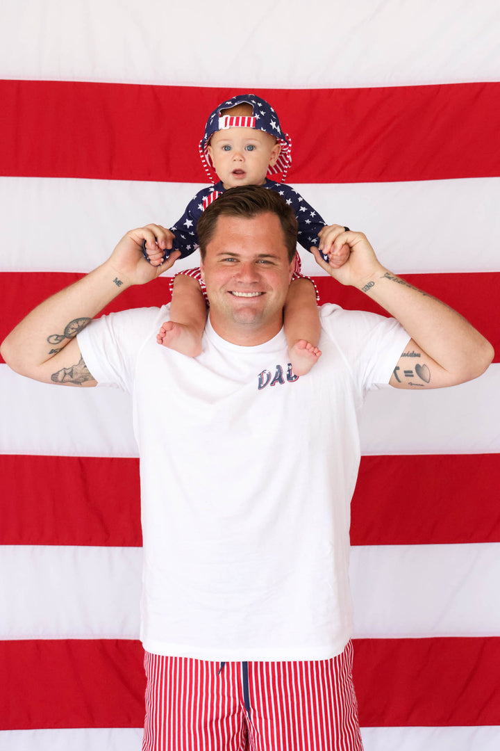 boy sitting on dad's shoulders in 4th of july matching swimwear
