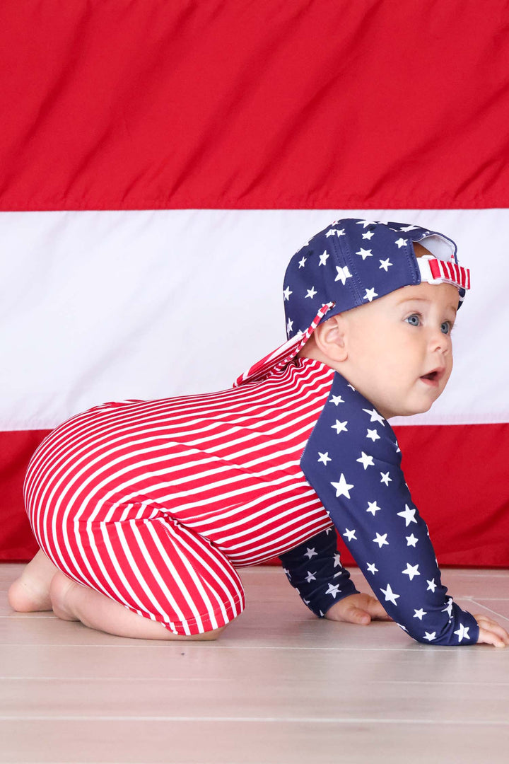 baby boy crawling in stars & stripes family matching swim romper shortie and matching surf hat 
