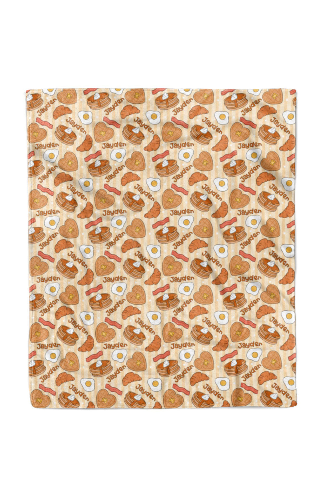 A Caden Lane blanket featuring a repeating cartoon breakfast pattern of eggs, bacon, pancakes, and toast on a light beige background.