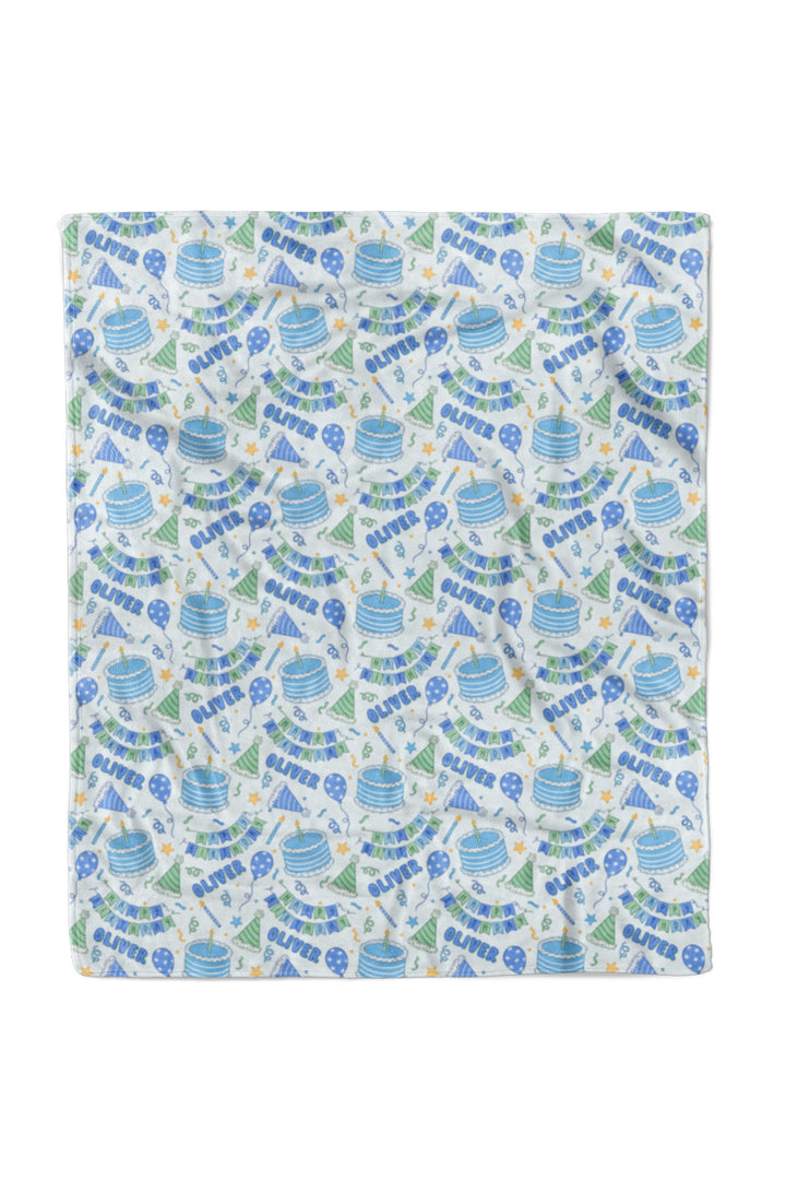A Caden Lane personalized kids blanket featuring a repeating party-themed pattern with blue and green illustrations of party hats, balloons, and streamers, alongside the text 'Happy Birthday' on a white background.