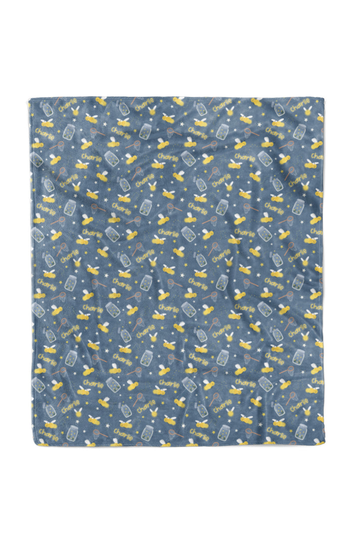 Flat lay of a Caden Lane blue 50x60 plush personalized blanket in a Chasing Fireflies print featuring fireflies and mason jars.