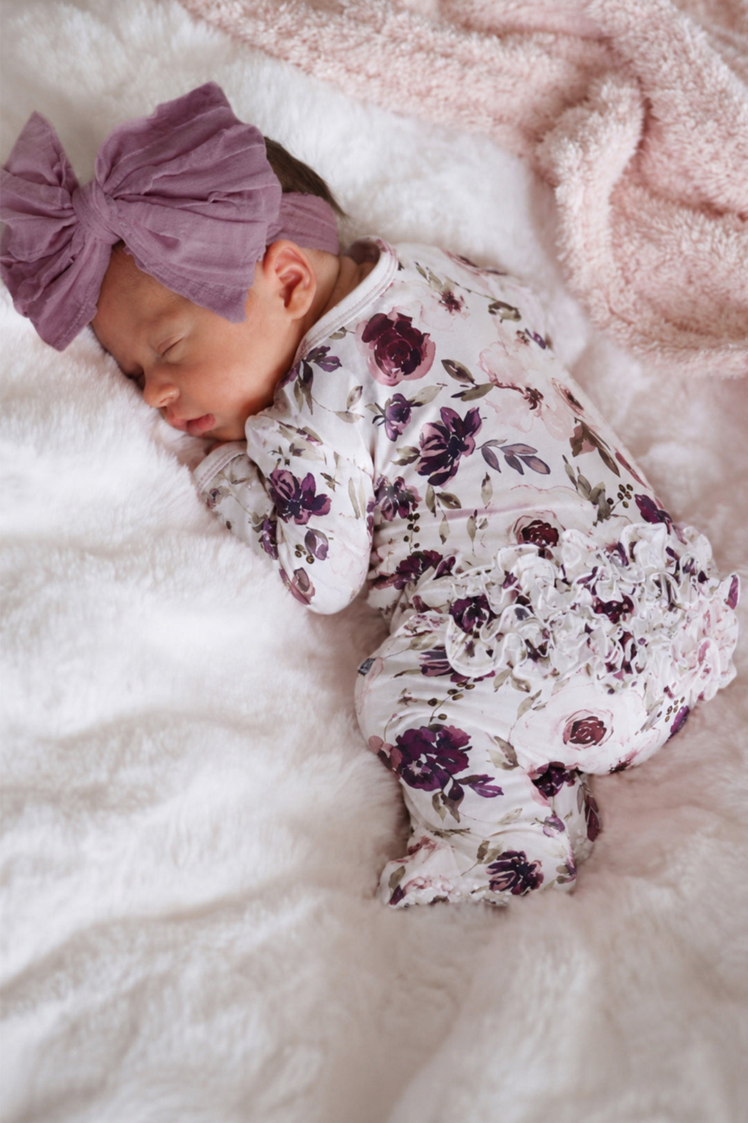 newborn sleeping wearing purple floral ruffle zipper footie 