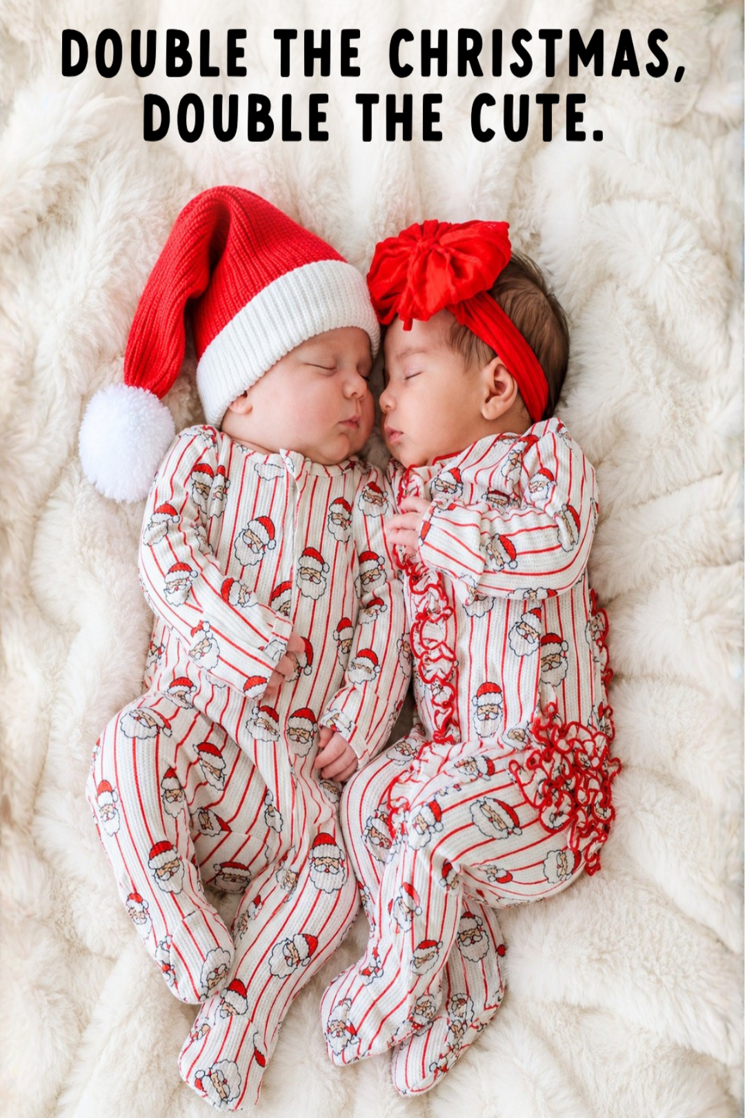 Two sleeping newborn babies lying side by side on a white faux fur blanket, wearing matching red and white Christmas-themed footed pajamas with Santa hat and bow headband. Text at the top reads: 'DOUBLE THE CHRISTMAS, DOUBLE THE CUTE.
