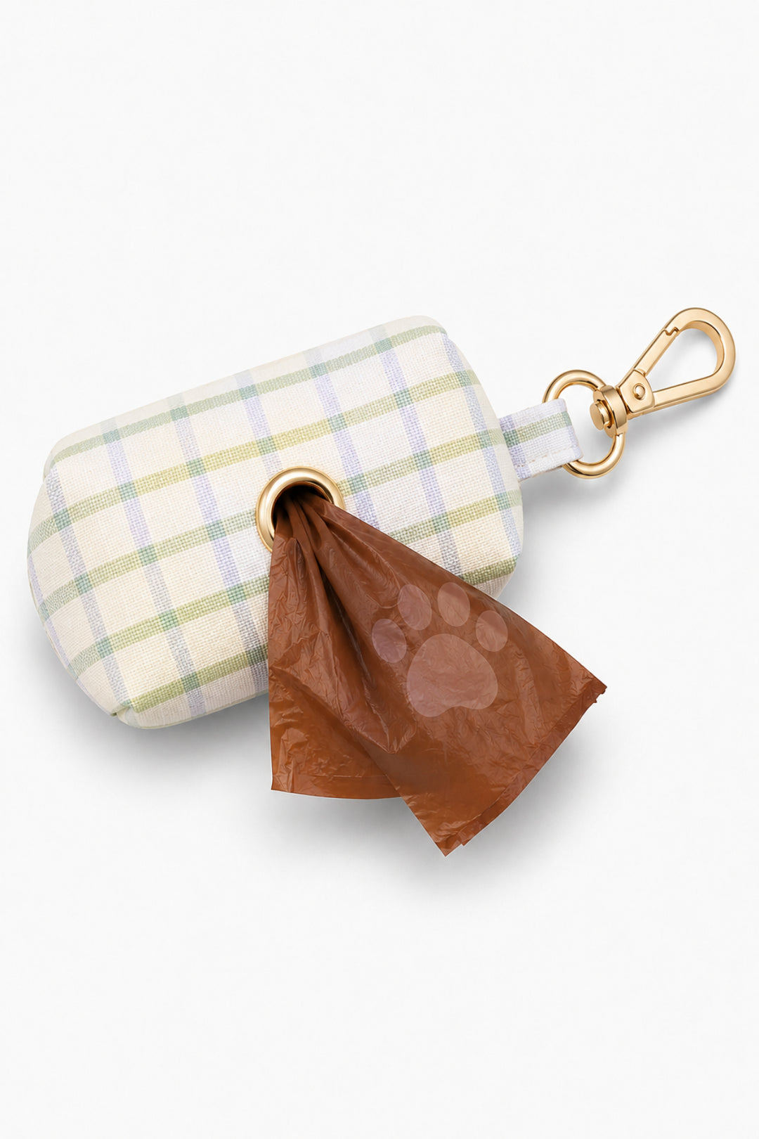 Pet waste bag holder in green and blue picnic plaid shown from the side with a brown waste bag dispensed from the bottom opening and gold carabiner clip attached