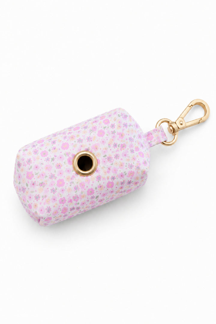 Bottom view of Scattered Blooms pet waste bag holder showing the bag dispensing opening, with Scattered Blooms floral print and gold clip hardware