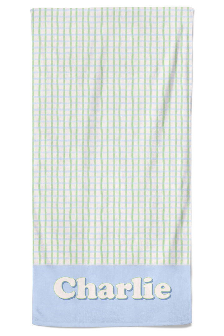 Personalized pet towel in green and blue picnic plaid with a blue bottom border and the name "Charlie" in white lettering