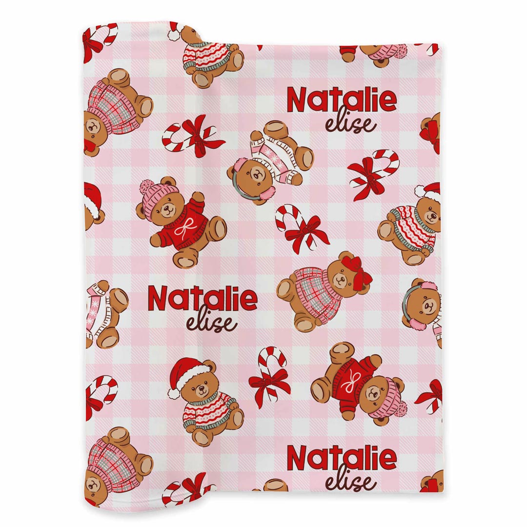 pink gingham personalized swaddle blanket for baby girls with teddy bears dressed in christmas sweater with santa hats and bows with candy canes scattered throughout