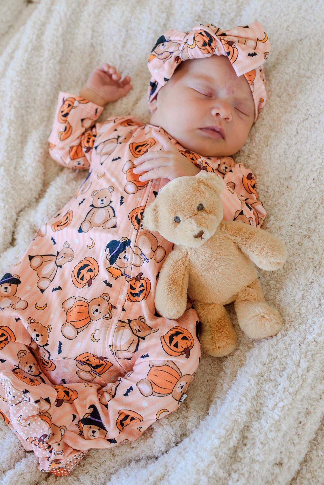 baby laying on soft blanket in beary scary zipper footie with matching headwrap
