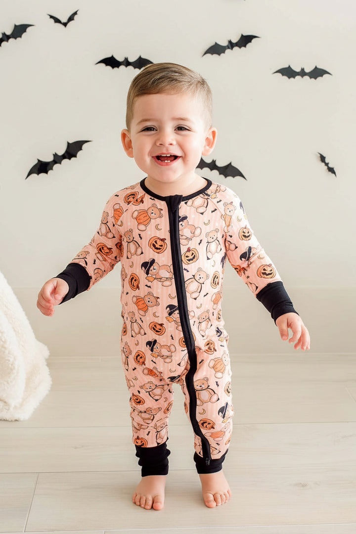 boy wearing beary scary convertible zip romper with bats in background