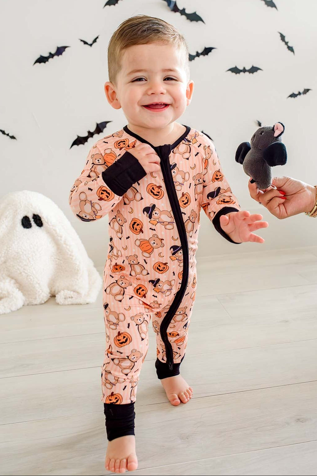boy walking with ghost and bat stuffed animals in beary scary zip romper