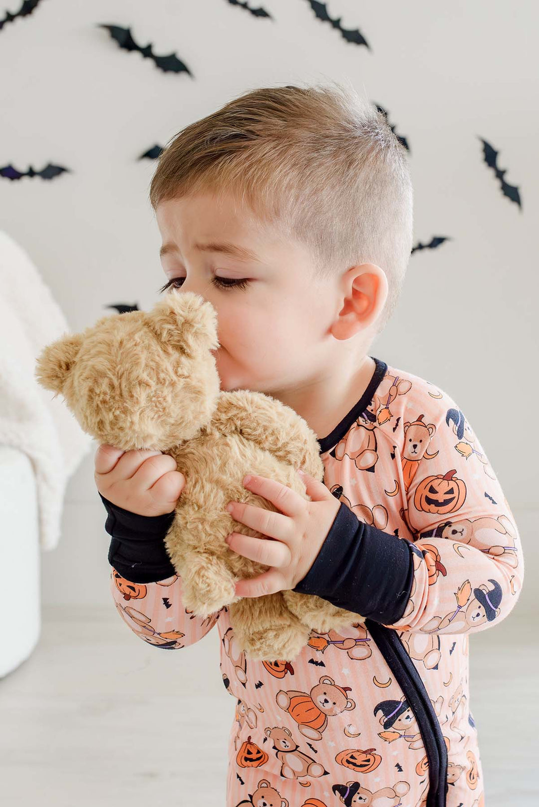 boy kissing bear stuffed animal in beary scary convertible zip romper