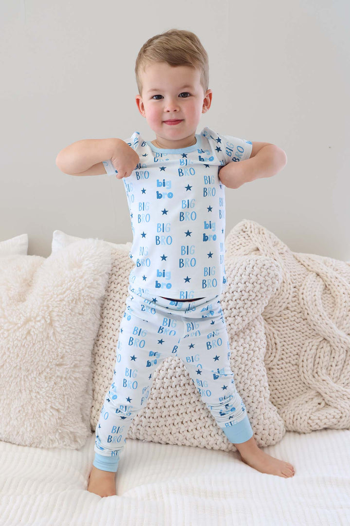 boy standing on bed in blue star big bro short sleeve two piece pajama set 