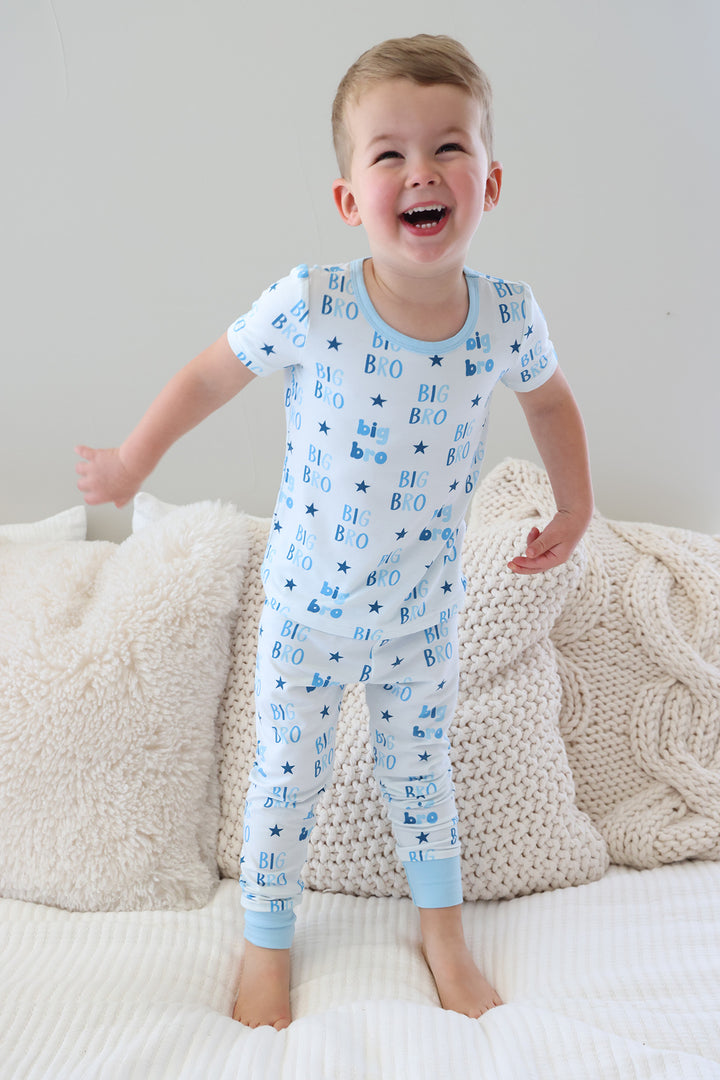 laughing boy jumping on the bed in blue star big bro two piece pajama set with short sleeves and pants 