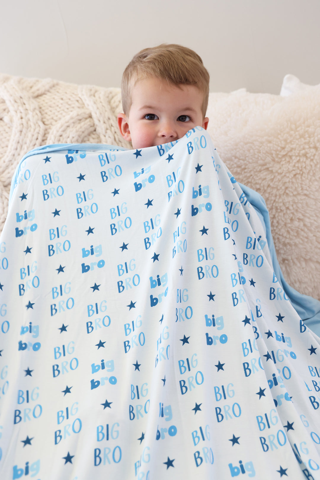 boy holding up big bro star double sided bamboo blanket blue 