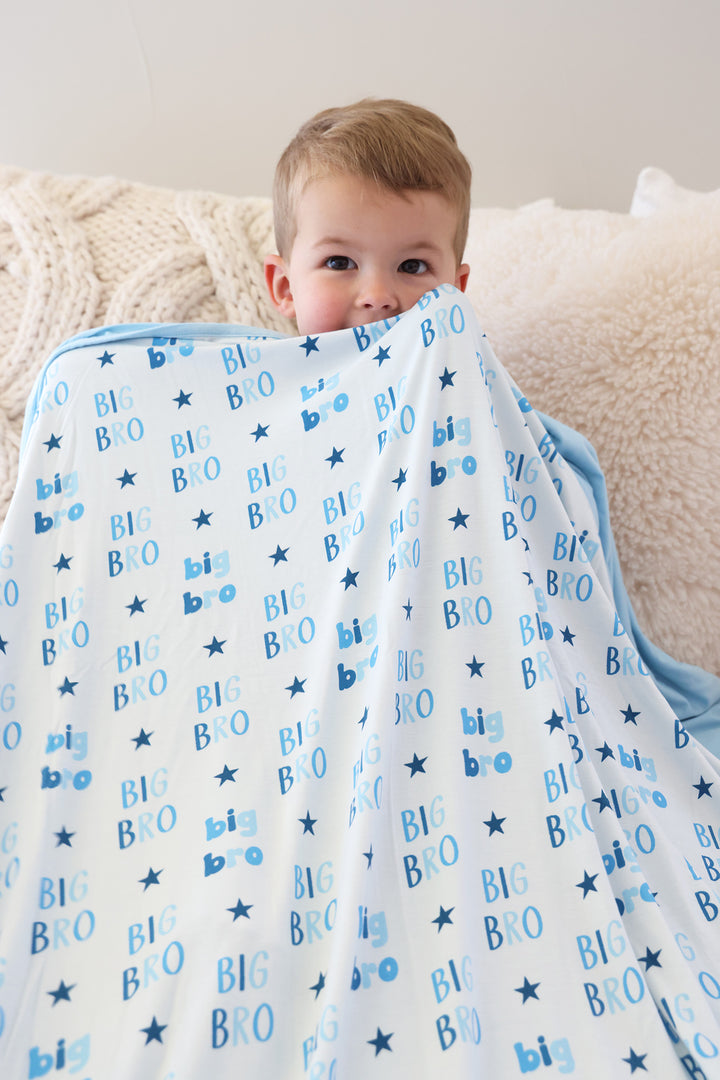 boy holding up big bro star double sided bamboo blanket blue 