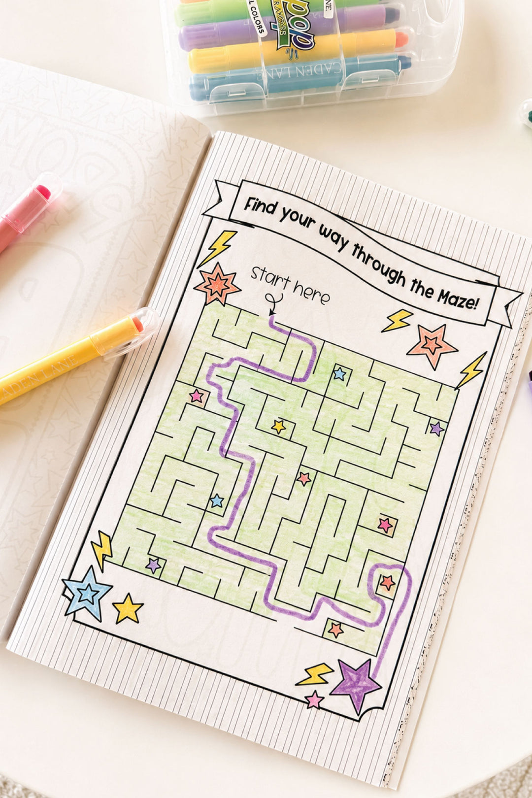 Interior maze activity page from the Caden Lane Best Big Brother coloring book, colored in with purple and green gel pens.