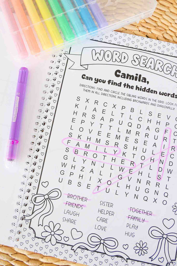 Personalized 'Camila' word search puzzle page from a Caden Lane Big Sister Coloring Book, partially completed with pink marker circling sibling-themed words like brother and friends