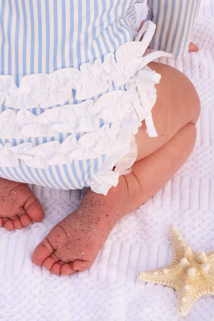 closeup of ruffle bottom rash guard swimsuit in blue seersucker 