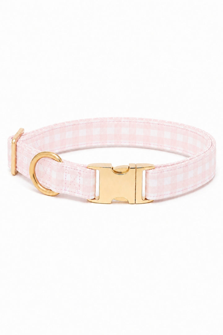A Lane & Leash light pink and white gingham check dog collar with gold-tone hardware, including a buckle, D-ring, and adjustment slider, shown on a plain white background.