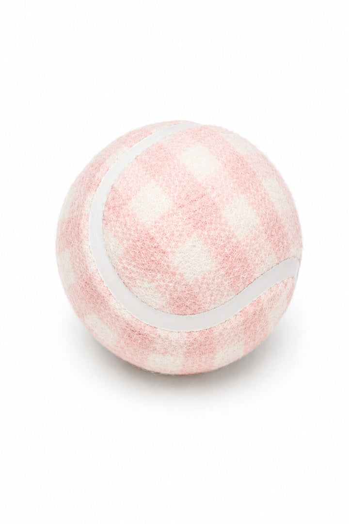 A Lane & Leash pink and white checkered tennis ball with a white dividing line, isolated on a white background.