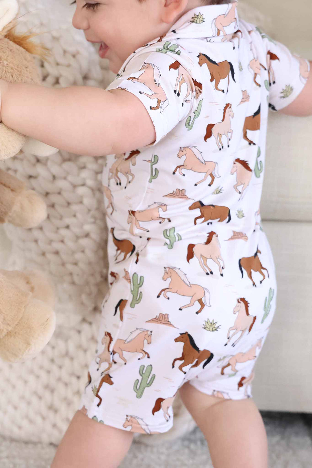 closeup of neutral pony club short romper for boys 