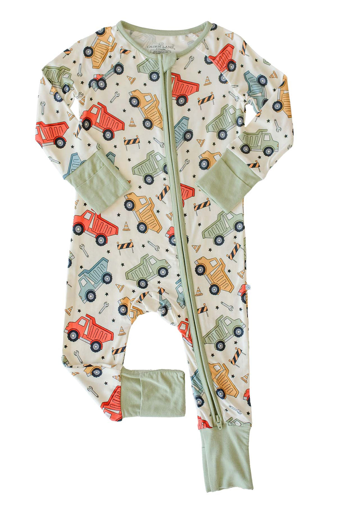 Flat lay of a Caden Lane cream knit zip romper in a Busy Builder print featuring dump trucks and wrenches, with one sage foot cuff folded closed.