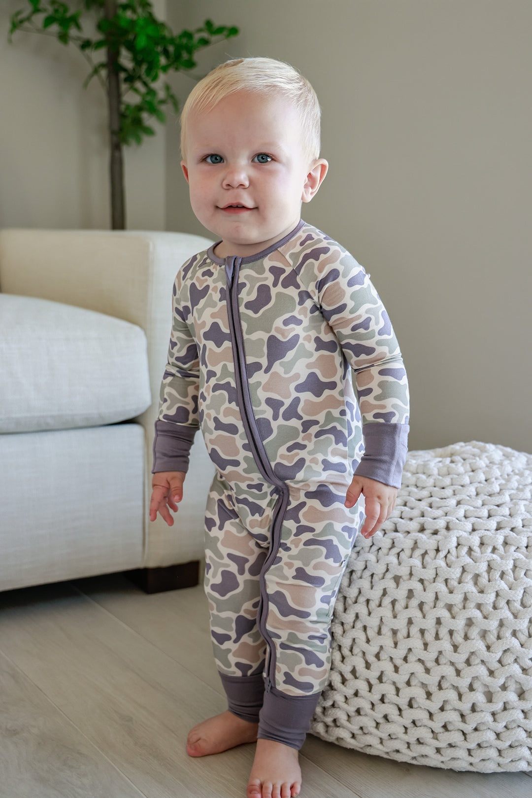 Camo cutie baby zip romper back view on sitting toddler