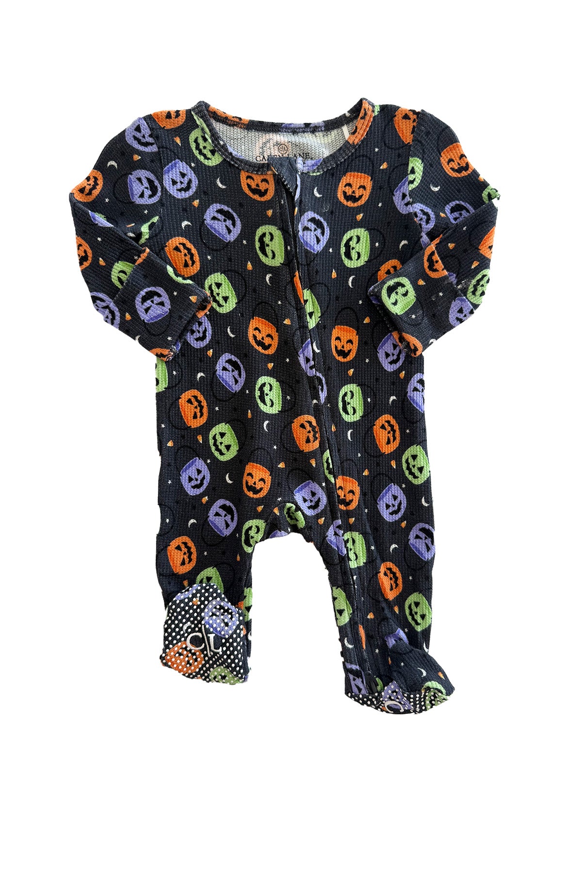 Bamboo waffle zipper footie in black with colorful jack-o-lantern print and polka dot footed bottoms, laid flat
