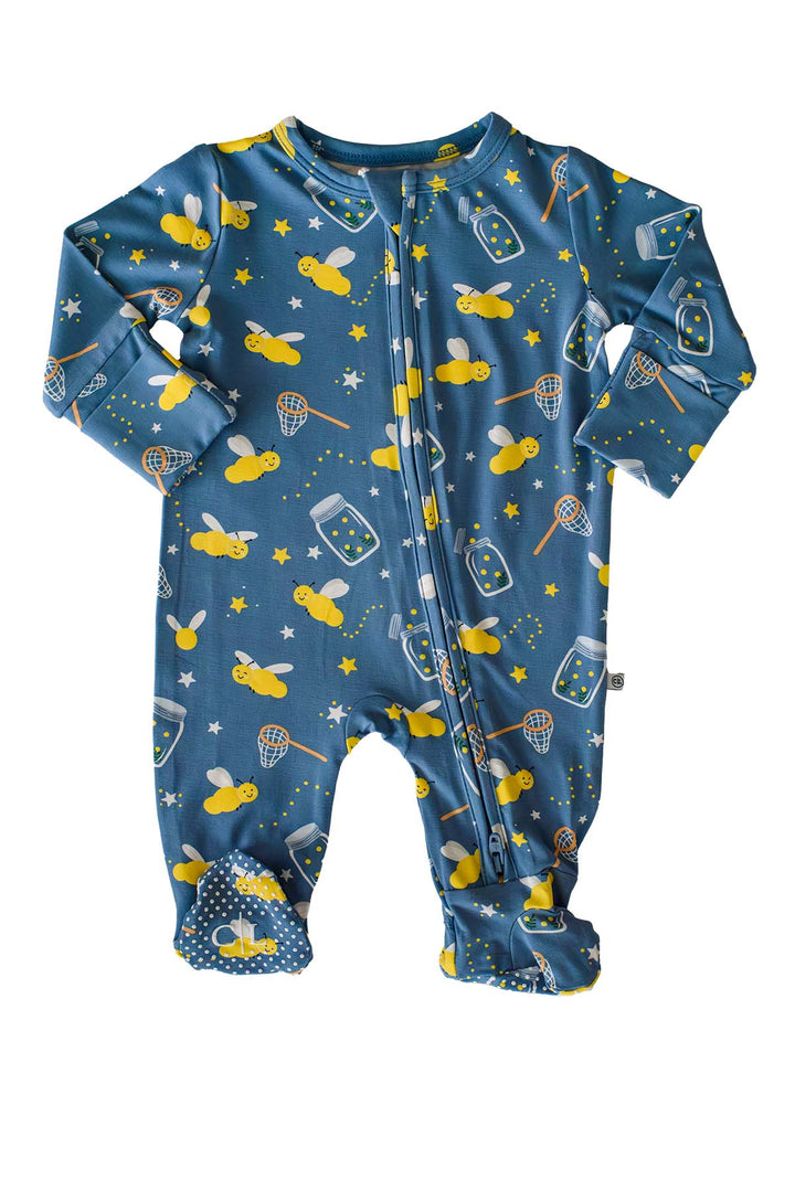 Flat lay of a Caden Lane blue bamboo zipper footie in a Chasing Fireflies print featuring fireflies and mason jars, with arms outstretched and polka-dot feet.