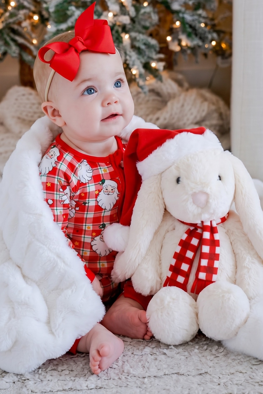 Baby wearing the Caden Lane Cozy Claus zip romper with the Christmas Bunny sitting next to her. 