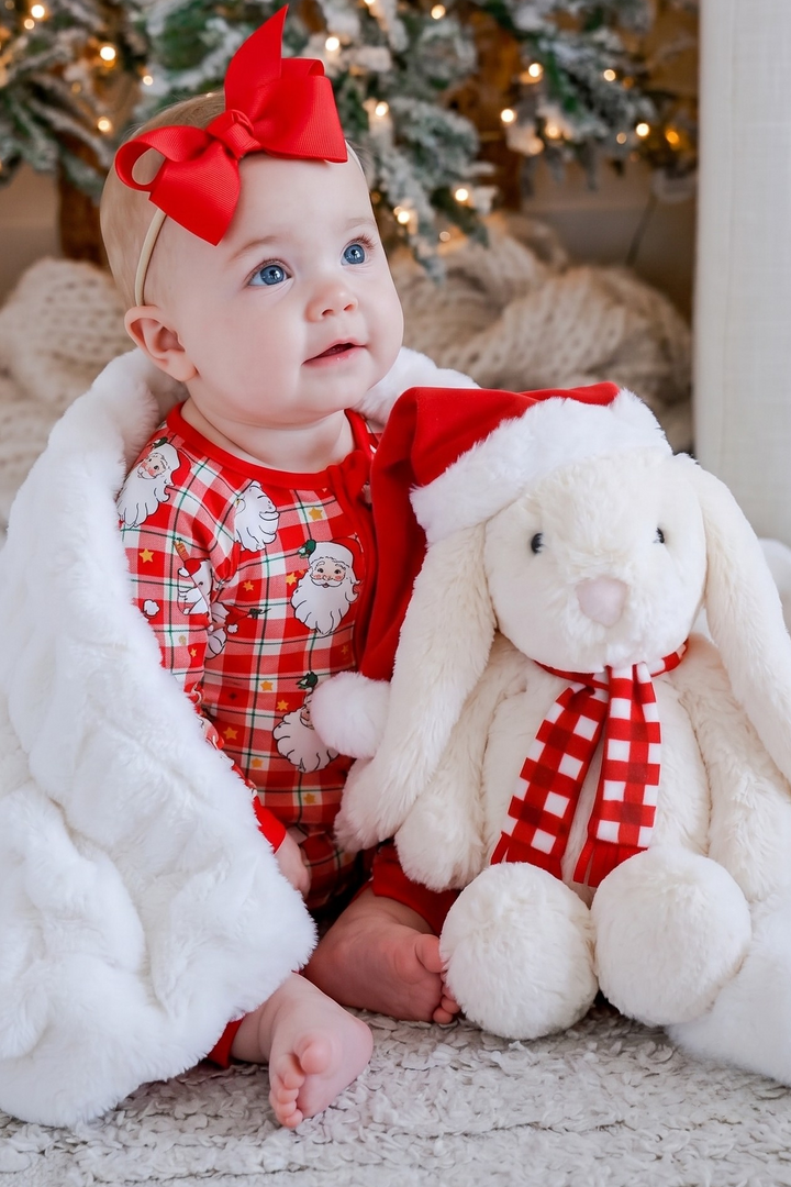 Baby wearing the Caden Lane Cozy Claus zip romper with the Christmas Bunny sitting next to her. 