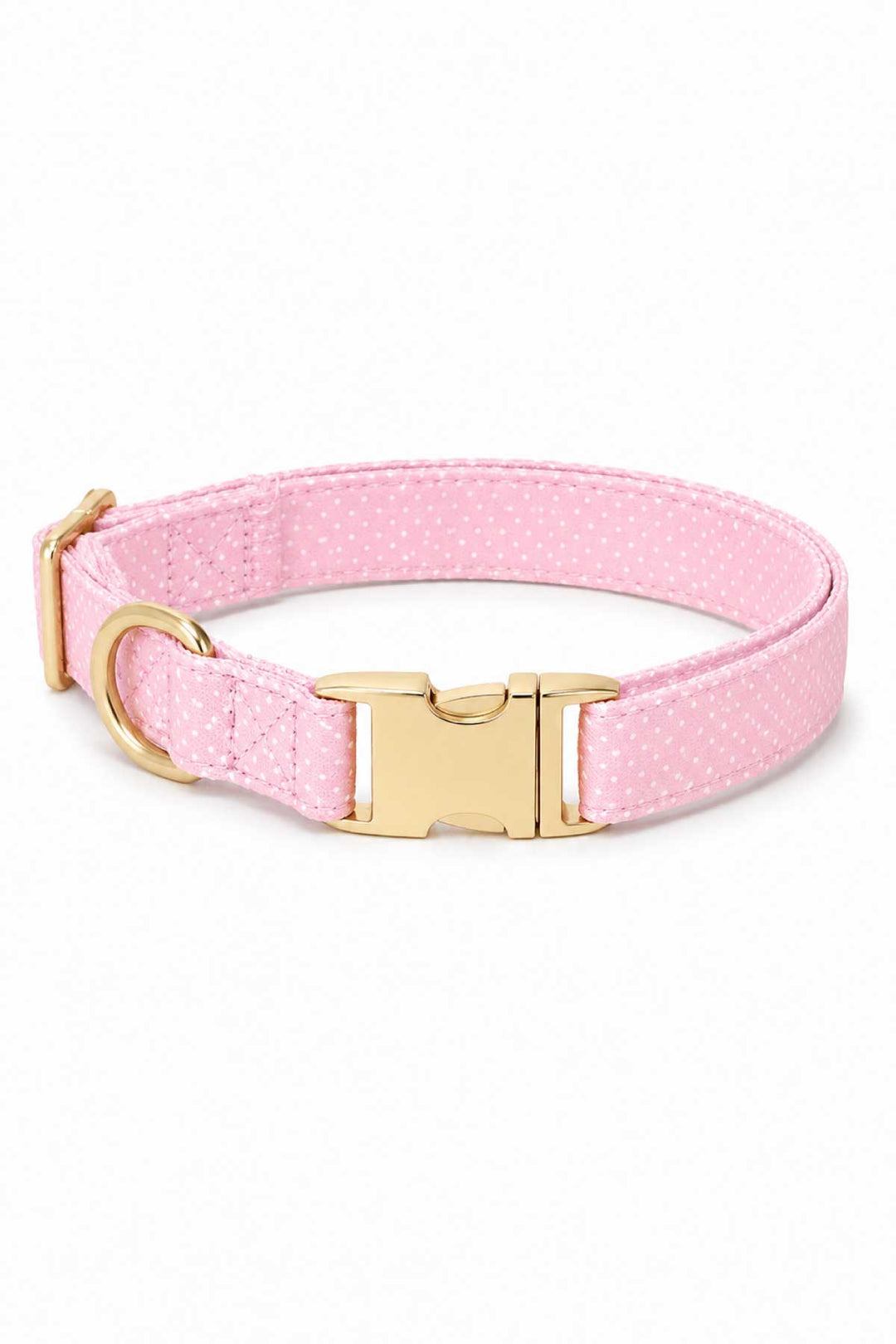 Pink polka dot dog collar with gold quick-release buckle and D-ring on a white background