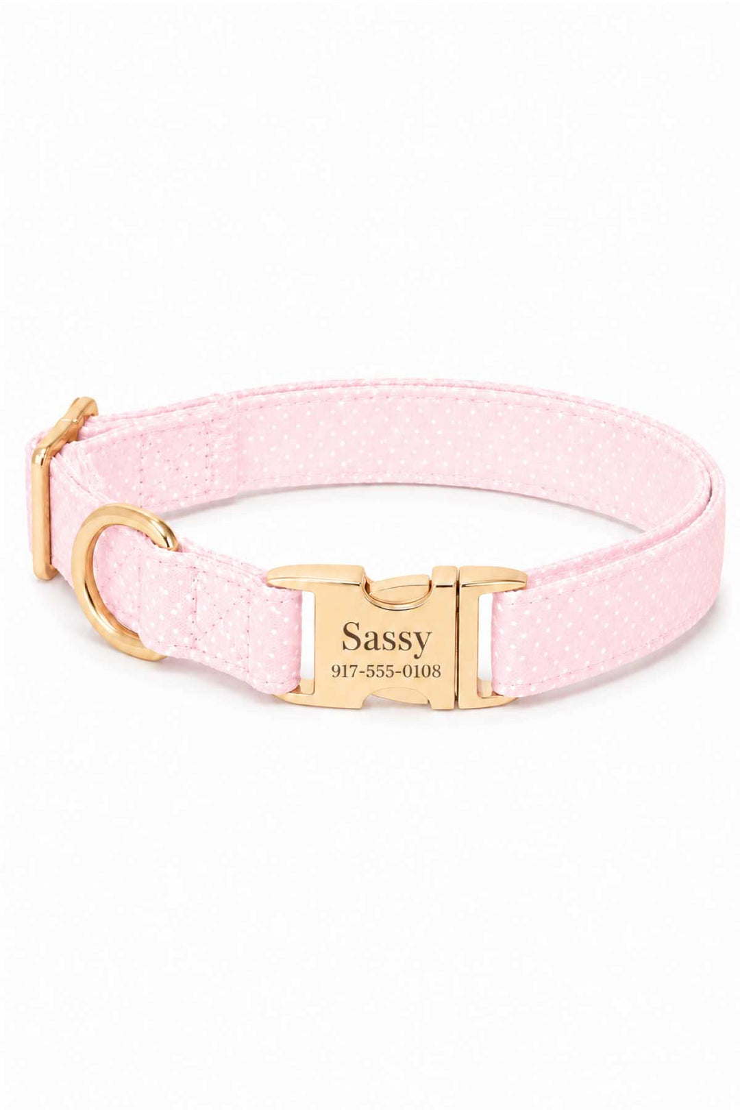 Pink polka dot dog collar with personalized gold ID tag engraved with the pet name and phone number, featuring gold hardware