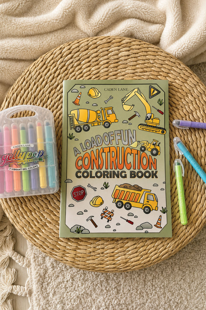 Caden Lane "A Load of Fun Construction" coloring book featuring trucks and diggers, styled with Gellypop gel crayons on a woven tray.
