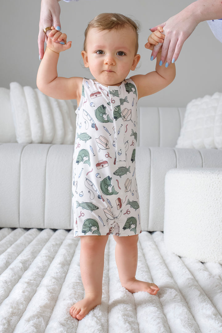 Baby holding parent hands while standing wearing the Off The Hook sleeveless snap romper front view