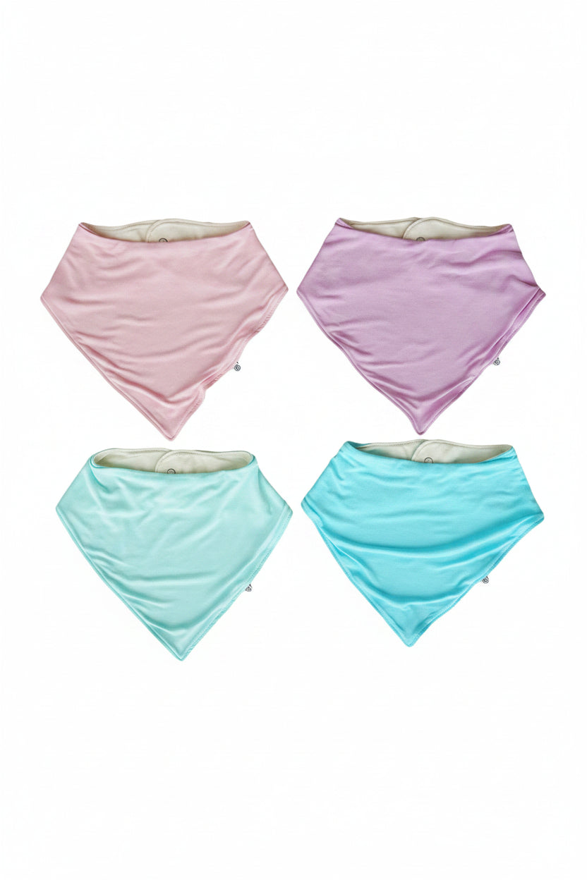 Four Caden Lane triangular bandana bibs in pastel pink, lavender, mint green, and turquoise on a white background. 