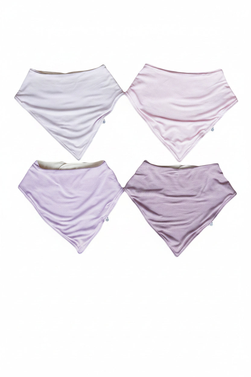 Four triangular folded Caden Lane baby bandana bibs in light pastel shades of purple,  on a plain white background.