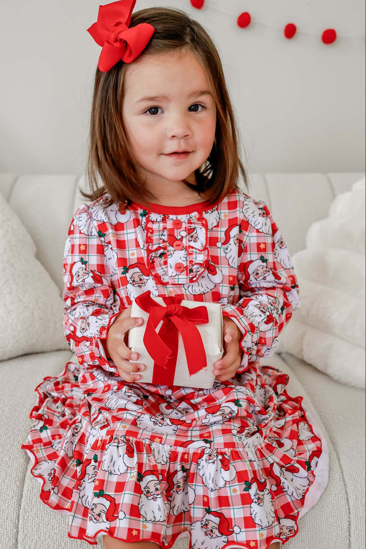 Toddler wearing a Caden Lane Cozy Claus long sleeve Christmas ruffle nightgown in a vintage Santa plaid print with festive red trim and ruffle details.