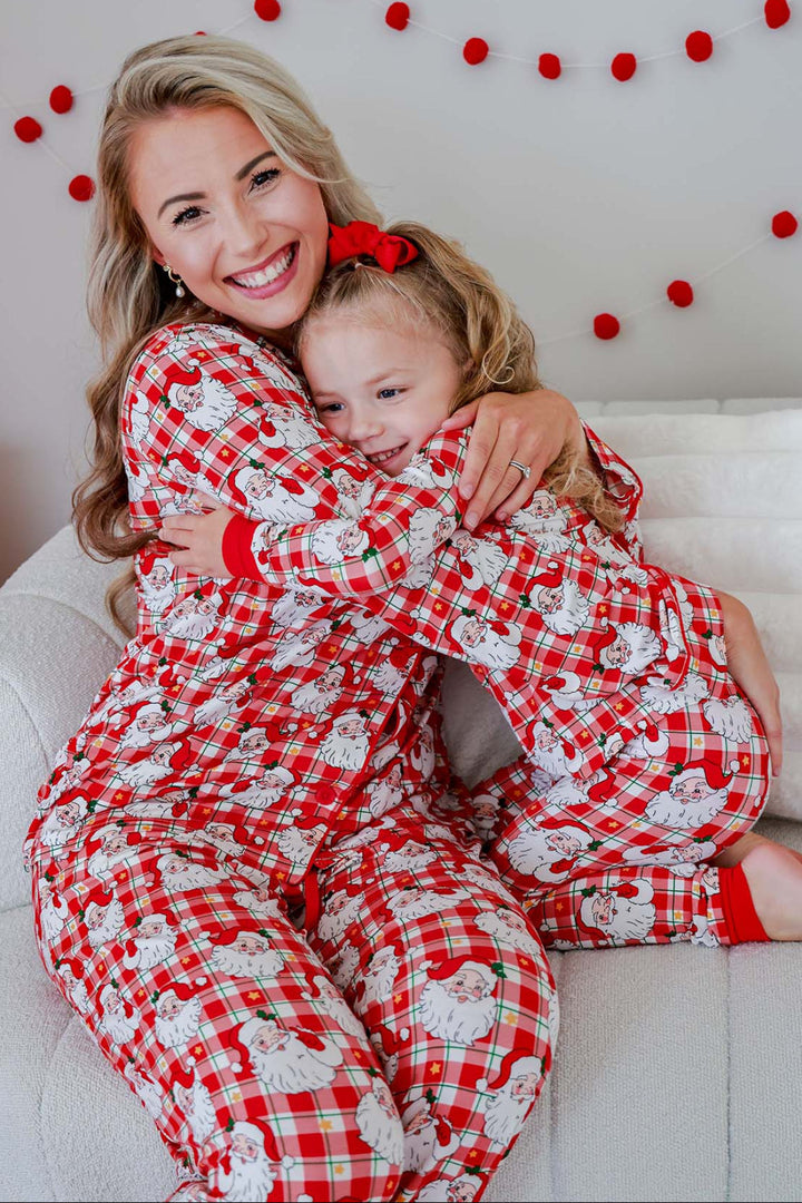 Mom and daughter wearing Caden Lane Cozy Claus matching Christmas bamboo pajamas featuring a vintage Santa plaid print, sharing a cozy holiday hug in festive family sleepwear.