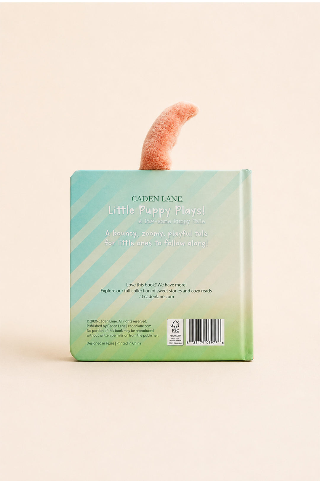 The back cover of the children's book 'Little Puppy Plays!' by Cadence Lane, featuring a pastel green and blue striped design with a small pink puppy tail graphic, set against a solid cream background.