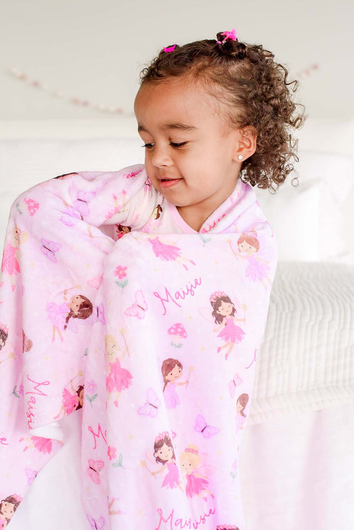Toddler girl cuddled in the soft pink Fairy Wishes personalized kids&