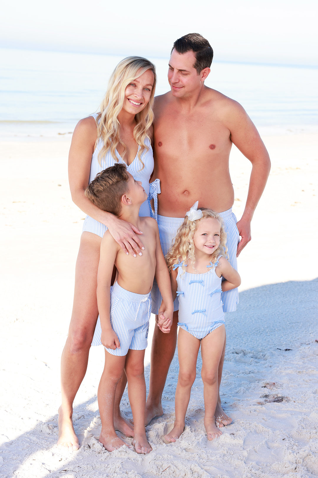 family wearing matching blue seersucker swimsuits 