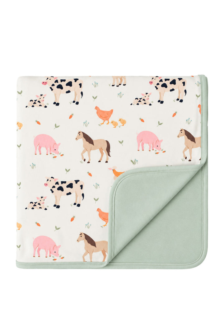 Caden Lane Farm Friends double-sided bamboo blanket featuring cows, pigs, horses, chickens, chicks, and a solid sage green reverse.