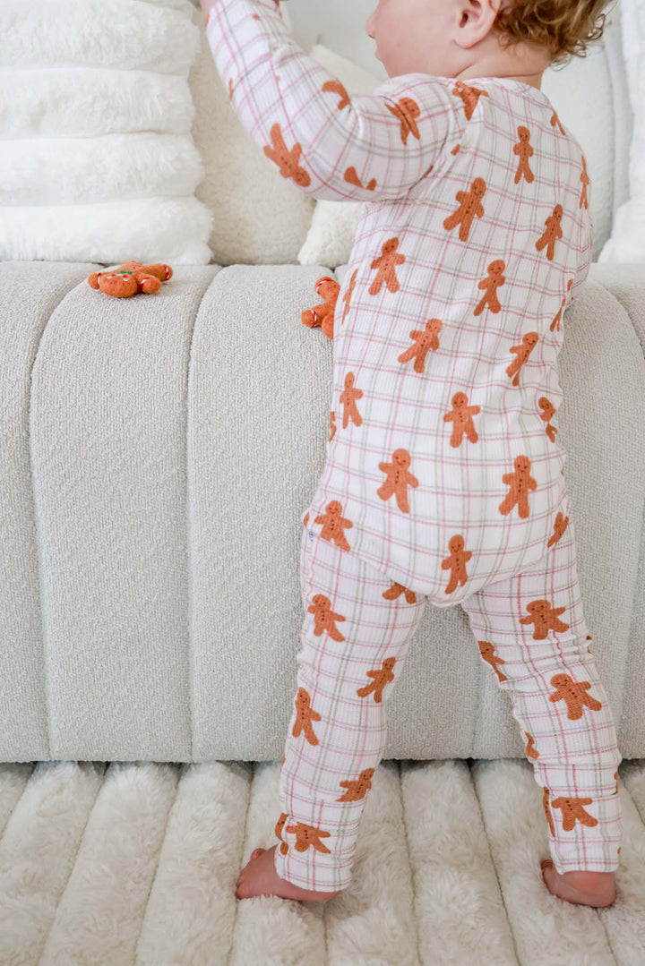 Caden Lane back view of a toddler wearing a bamboo gingerbread cookie plaid zipper romper, showcasing the playful Christmas print and comfortable fit for babies and toddlers.